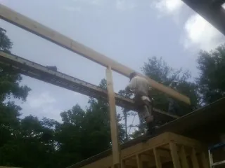 Carpenter setting a ridge beam over a new addition frame — Ice Dam Removal by Roofing Brothers in Llano