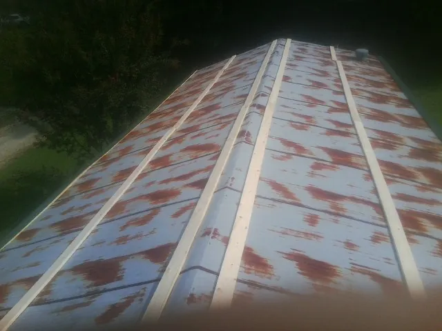 Rusted metal roof panels with new wood purlins before replacement — Storm Damage Roof Repair in Llano by Roofing Brothers