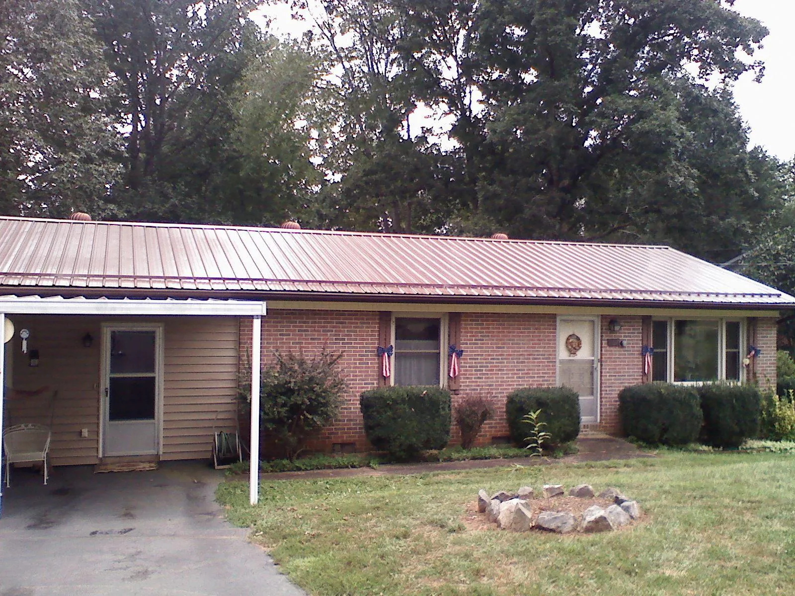 Bronze metal roof and carport on a brick ranch home — Roof Repair work by our crew in Llano
