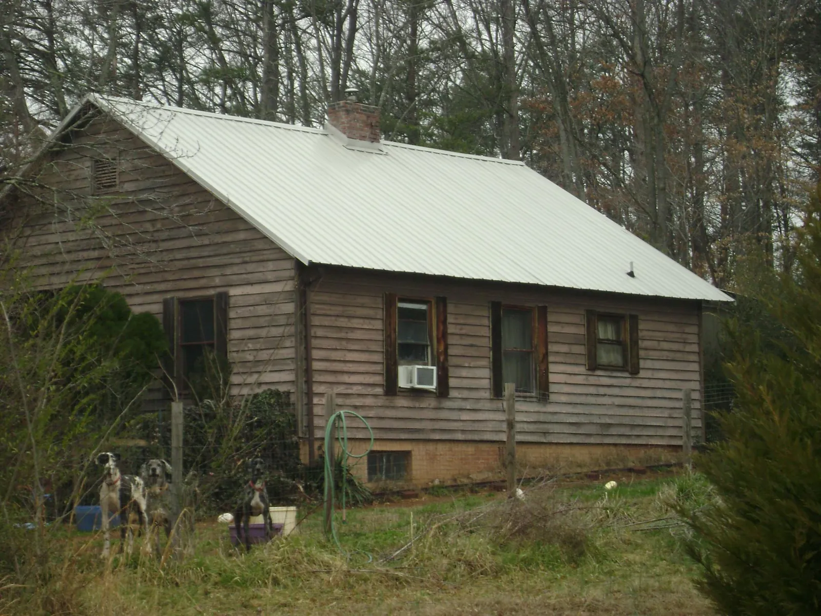 White metal roof on an old wood sided farmhouse, from a Asphalt Shingle Roof Repair job in Llano